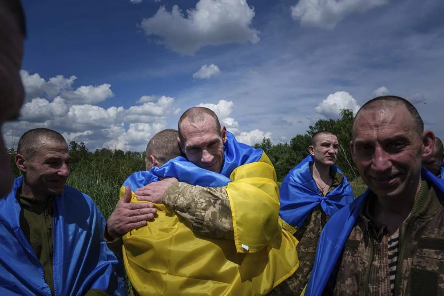 A Ukrainian serviceman hugs his comrade after returning from captivity during a POWs exchange in Sumy region, Ukraine, Friday, May 31, 2024. (AP)