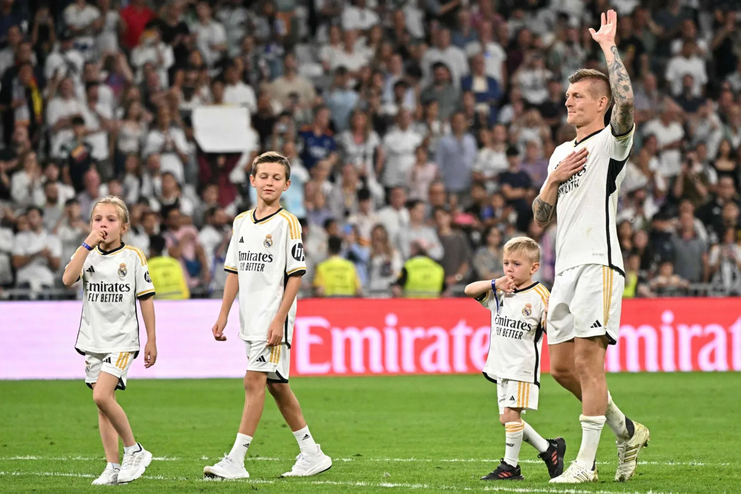 توني كروس مع أطفاله يودع جماهير ريال مدريد بعد الجولة الأخيرة من الدوري الإسباني (أ.ف.ب)