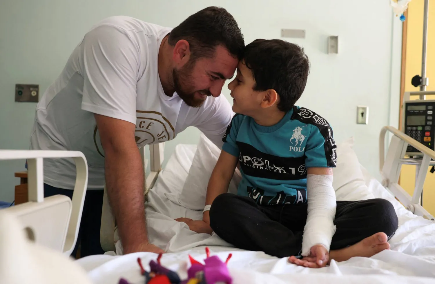 5-year-old Adam Afana, the first Palestinian child wounded in Israel's war on Gaza to land in Lebanon, plays with his uncle Eid Afana, as he sits on a hospital bed at the American University of Beirut's Medical Center in Beirut, Lebanon May 31, 2024. Reuters

