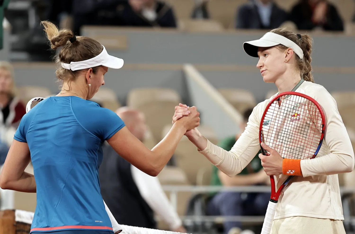 ريباكينا (يمين) تصافح ميرتينز بعد فوزها عليها في «رولان غاروس» (إ.ب.أ)