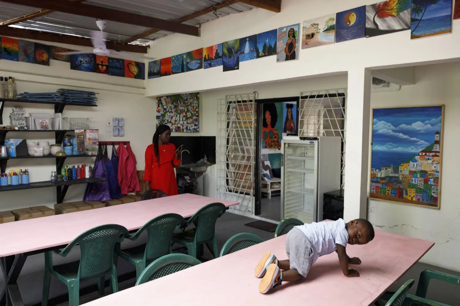 Ace-Liam Nana Sam Ankrah, who will turn two in July, plays on a table at his mother's art gallery in Accra, Ghana, Monday, May 27, 2024. (AP Photo/Misper Apawu)
