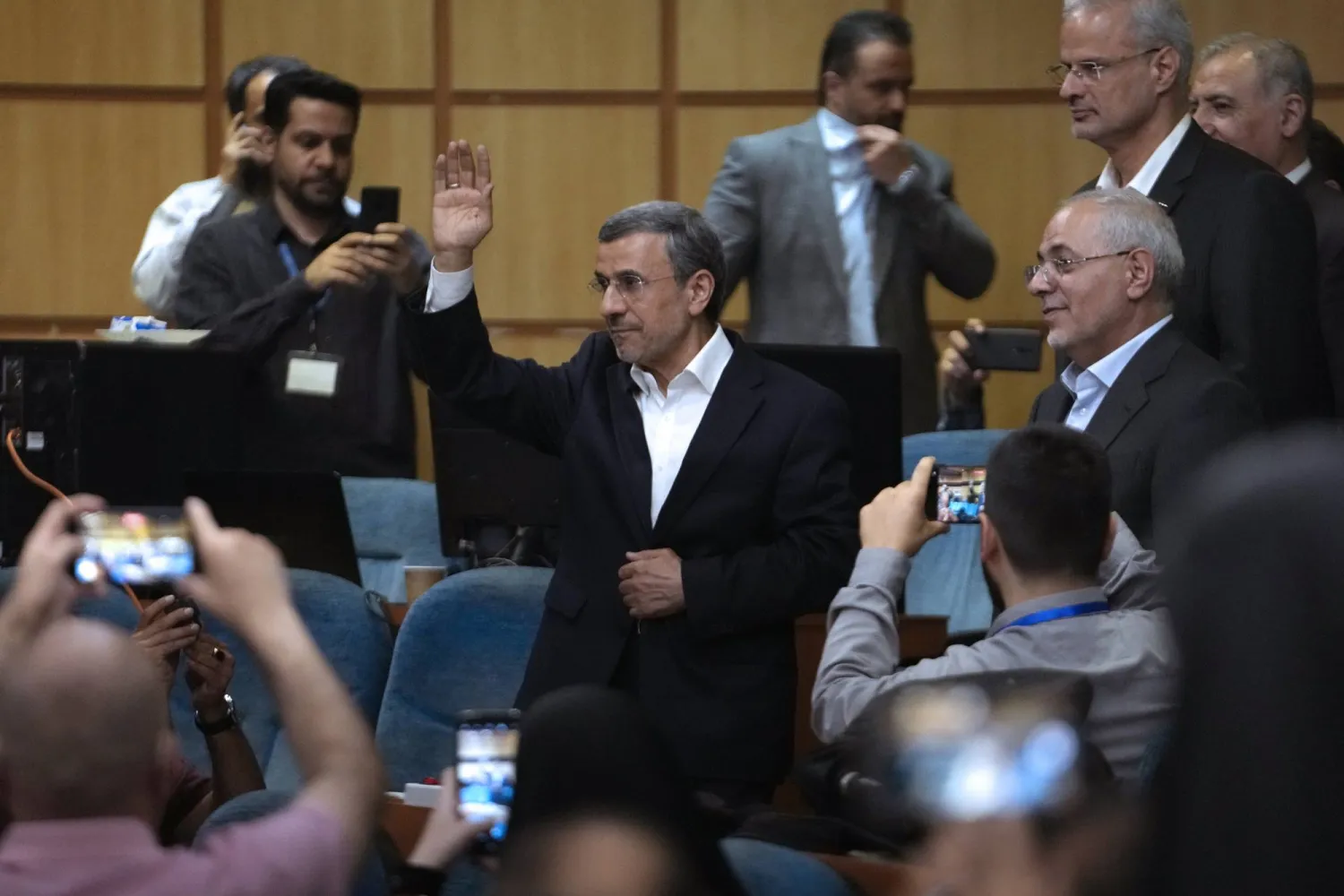 Iran's former President Mahmoud Ahmadinejad waves to the media as he arrives for a press briefing after registering his name as a candidate for the June 28 presidential election at the Interior Ministry, in Tehran, Iran, Sunday, June 2, 2024. (AP Photo/Vahid Salemi)