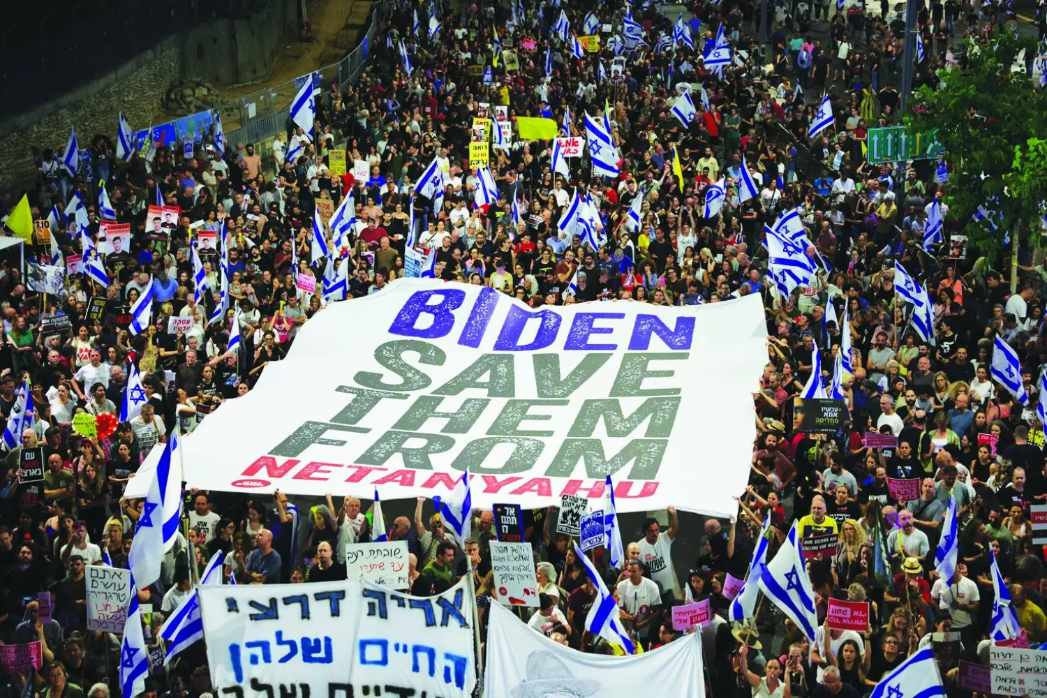 
لافتة كبيرة في مظاهرة أمام مقر القيادة العسكرية الإسرائيلية في كريا مساء أمس تقول: «بايدن... أنقذ المحتجزين من نتنياهو» (إ.ب.أ)