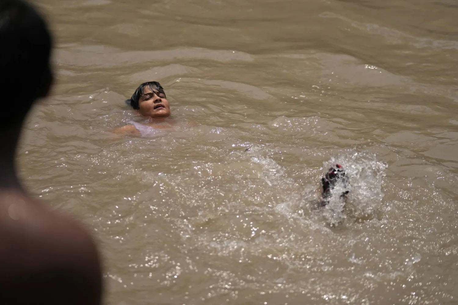 طفل يغمر نفسه بالمياه في جامو (أ.ب)