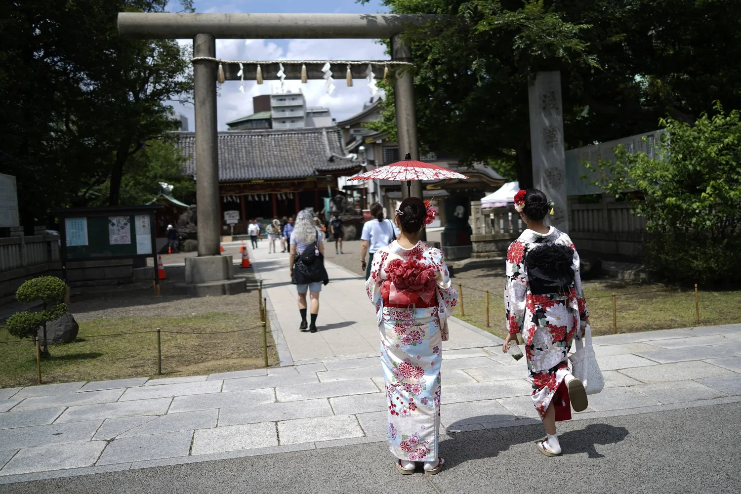 سيدات يرتدين زي الكيمونو الياباني التقليدي لدى دخول أحد المزارات التاريخية في العاصمة طوكيو (أ.ب)
