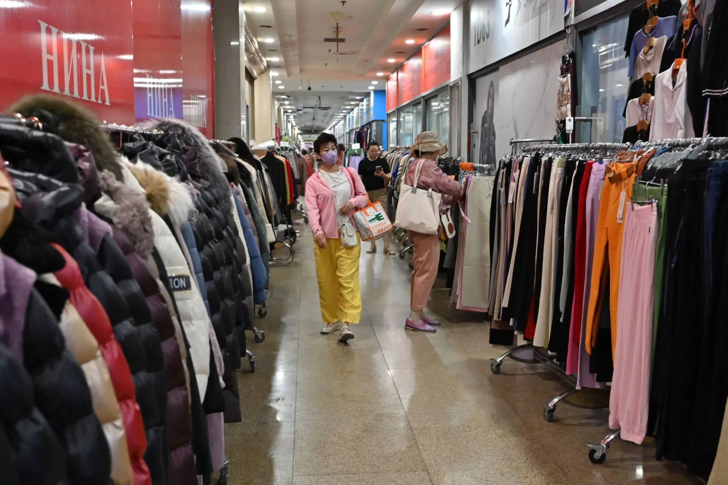 متسوقون داخل أحد متاجر الملابس في العاصمة الصينية بكين (أ.ف.ب)