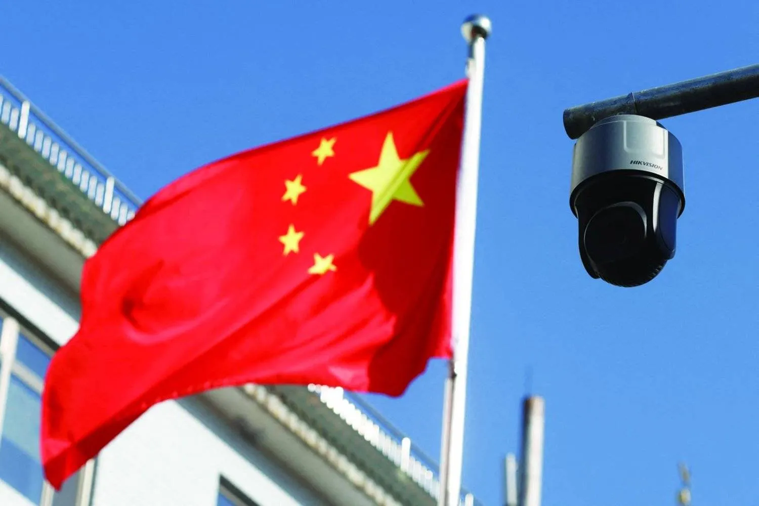 FILE PHOTO: A security surveillance camera overlooking a street is pictured next to a nearby fluttering flag of China in Beijing, China November 25, 2021. Picture taken November 25, 2021. REUTERS/Carlos Garcia Rawlins/File Photo
