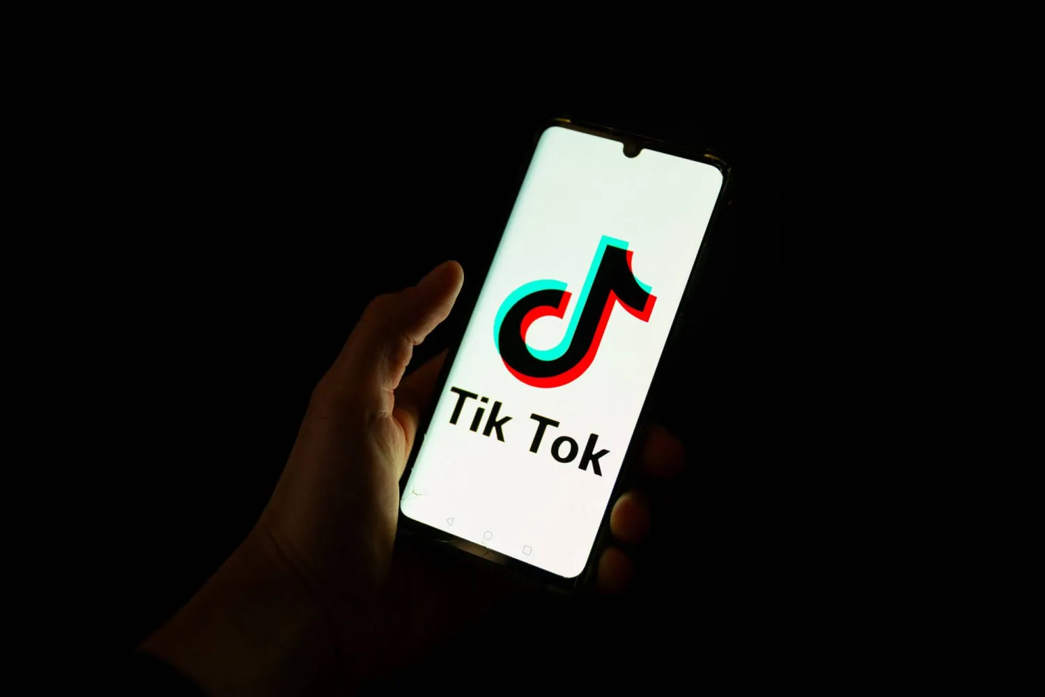 (FILES) This photograph taken on April 19, 2024 shows a man holding a smartphone displaying the logo of Chinese social media platform Tiktok in an office in Paris. (Photo by Antonin UTZ / AFP)