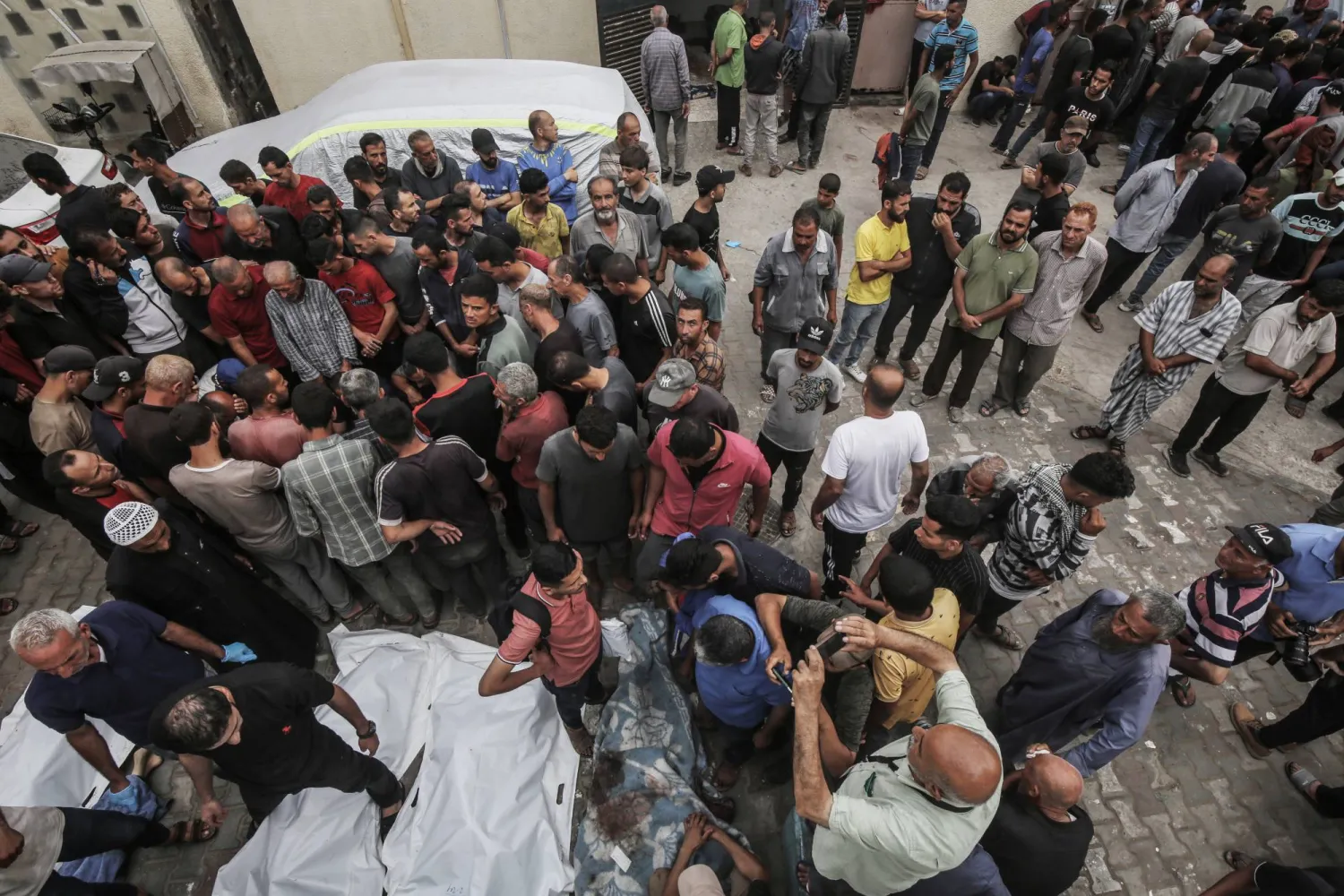 الفلسطينيون ينعون أقاربهم الذين قُتلوا في غارة جوية إسرائيلية خارج مستشفى «شهداء الأقصى» في دير البلح (د.ب.أ)