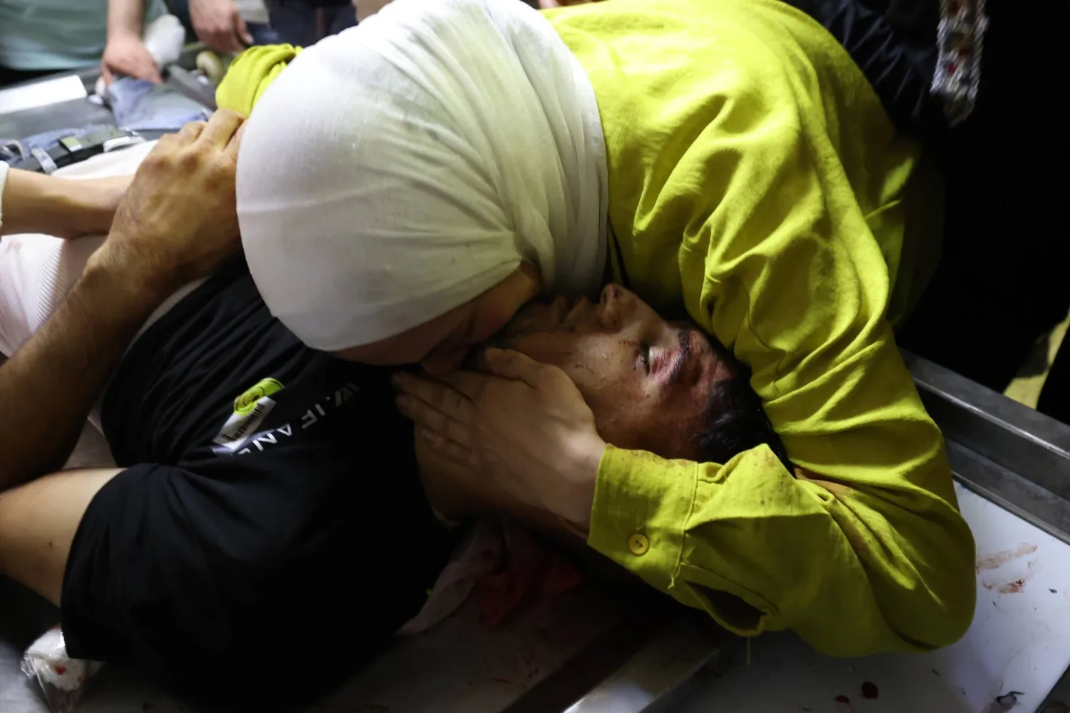 أقارب الفلسطيني معتز النابلسي يودعونه في مستشفى «رفيديا» بعد مقتله في مدينة نابلس بالضفة الغربية اليوم (إ.ب.أ)