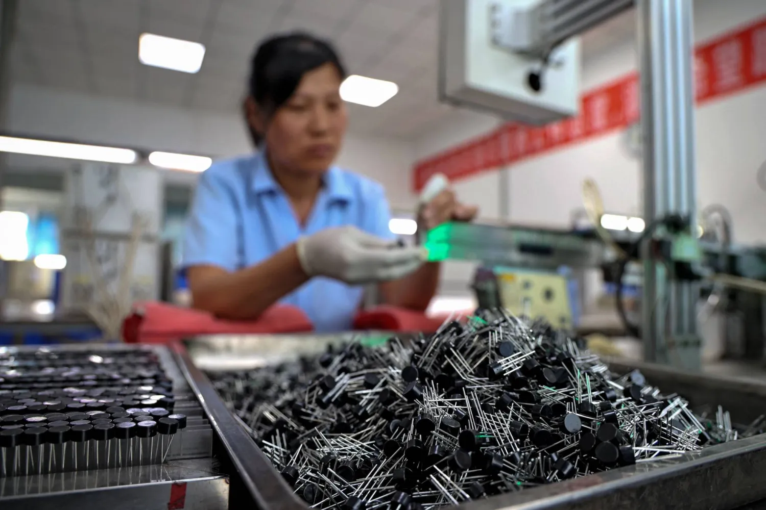 عاملة في أحد مصانع الرقائق الإلكترونية في مقاطعة شاندونغ شرق الصين (أ.ف.ب)