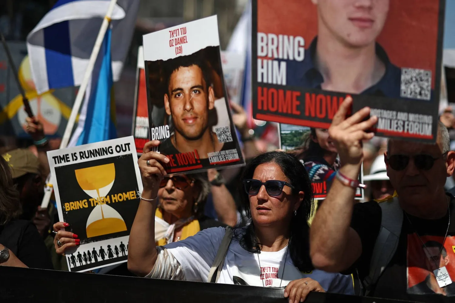 متظاهرون إسرائيليون يحملون صور الرهائن لدى «حماس» (أ.ف.ب)