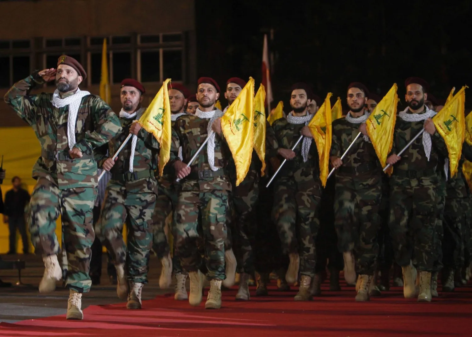 Beyrut'ta düzenlenen bir geçit töreni sırasında bayraklarla yürüyen Hizbullah üyeleri, 31 Mayıs 2019 (Reuters)