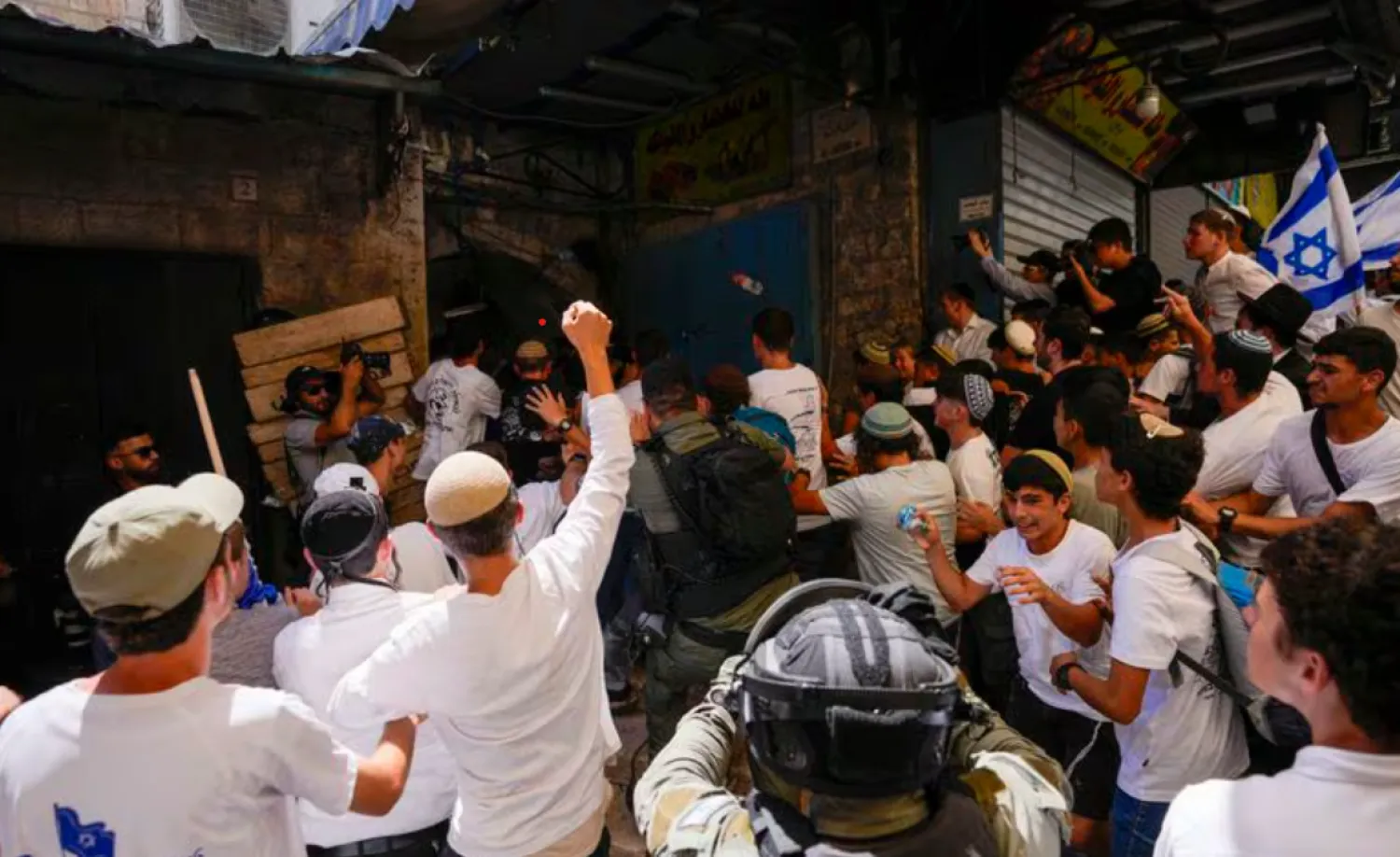 Israeli police officers separate Israelis and Palestinians in a street in the Muslim Quarter of Jerusalem's Old City, shortly before a march through the area by Jewish nationalists in Jerusalem Day, an Israeli holiday celebrating the capture of east Jerusalem in the 1967 Mideast war, Wednesday, June 5, 2024. (AP Photo/Ohad Zwigenberg)
