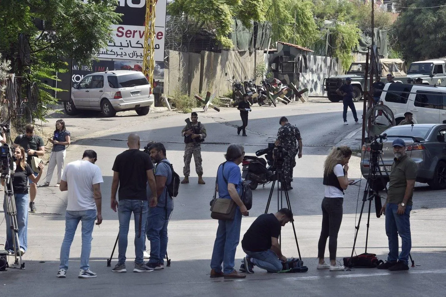 Journalists and photographers wait on the road leading to the US Embassy in Awkar following the shooting. (EPA)