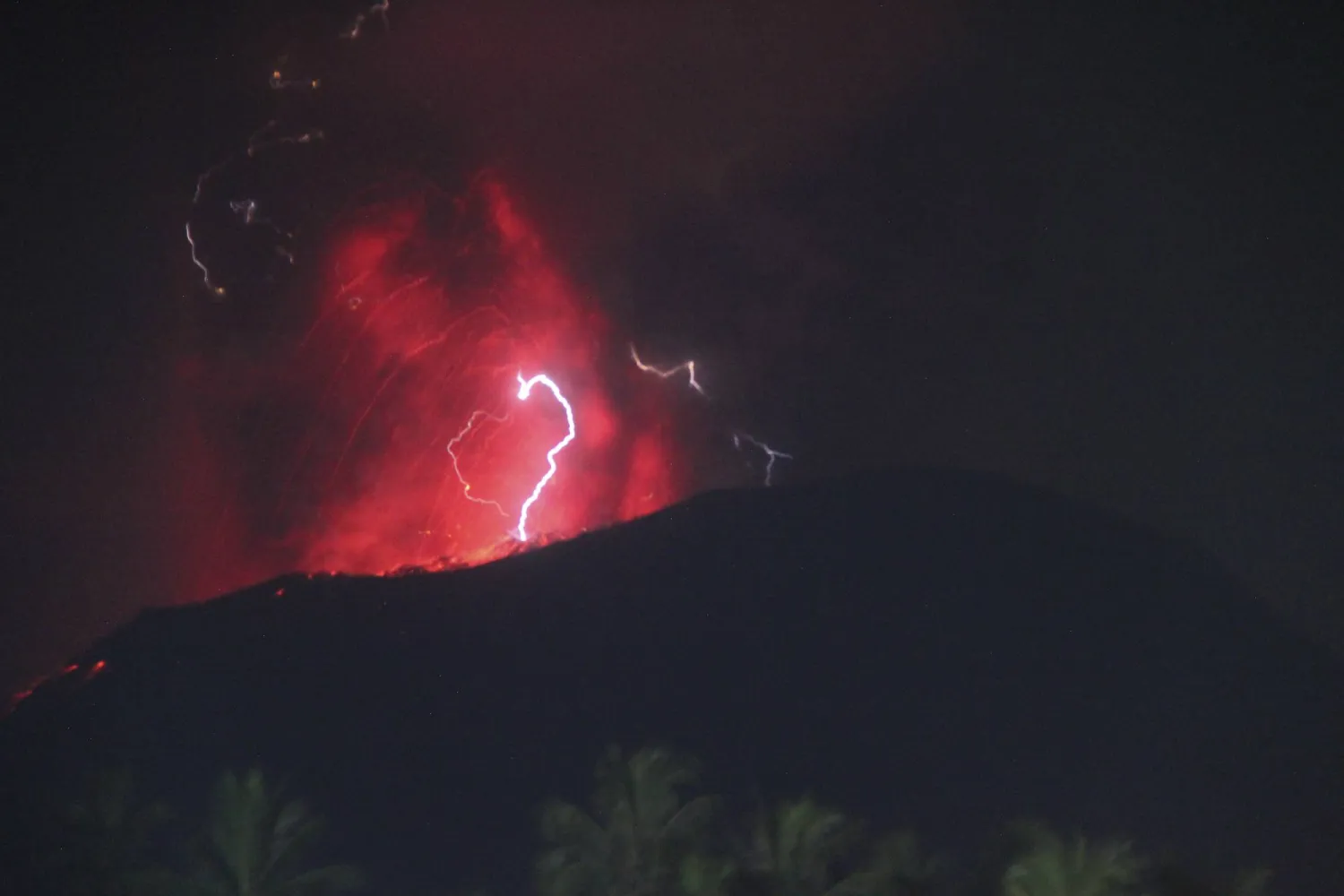 In this photo video released by Indonesia's Geological Agency of the Ministry of Energy and Mineral Resources (Badan Geology), the night sky glows as Mount Ibu spews volcanic materials during an eruption on Halmahera Island, Indonesia, Thursday, June 6, 2024. (Badan Geologi via AP)