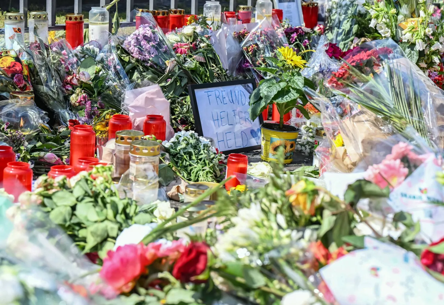 تم وضع الزهور والشموع في محيط مسرح الجريمة في ساحة السوق في مانهايم بعد مقتل ضابط شرطة في هجوم بسكين أدى إلى إصابة عدة أشخاص (د.ب.أ)