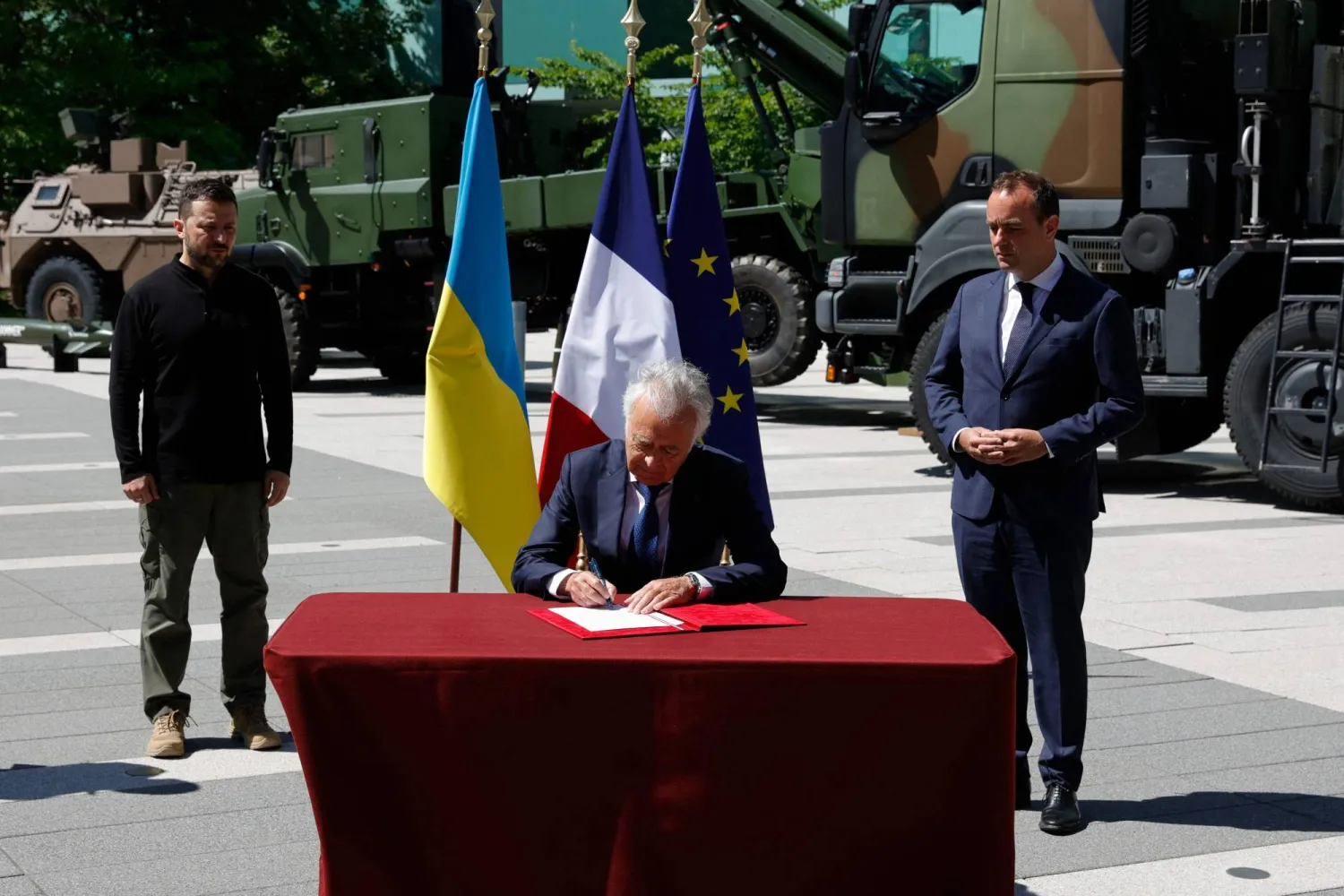 رئيس مجلس إدارة شركة «كي إن دي إس» يوقع وثيقة إنشاء فرع تابع لها في أوكرانيا أمام الرئيس الأوكراني فولوديمير زيلينسكي ووزير الدفاع الفرنسي سيباستيان لوكورنو (أ.ف.ب)