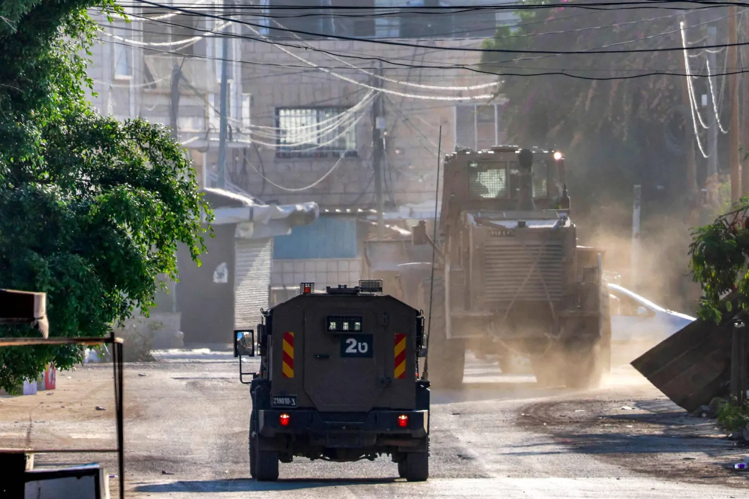 آلية عسكرية إسرائيلية وجرّافة خلال اقتحام لمخيم جنين في الضفة الغربية (أ.ف.ب)