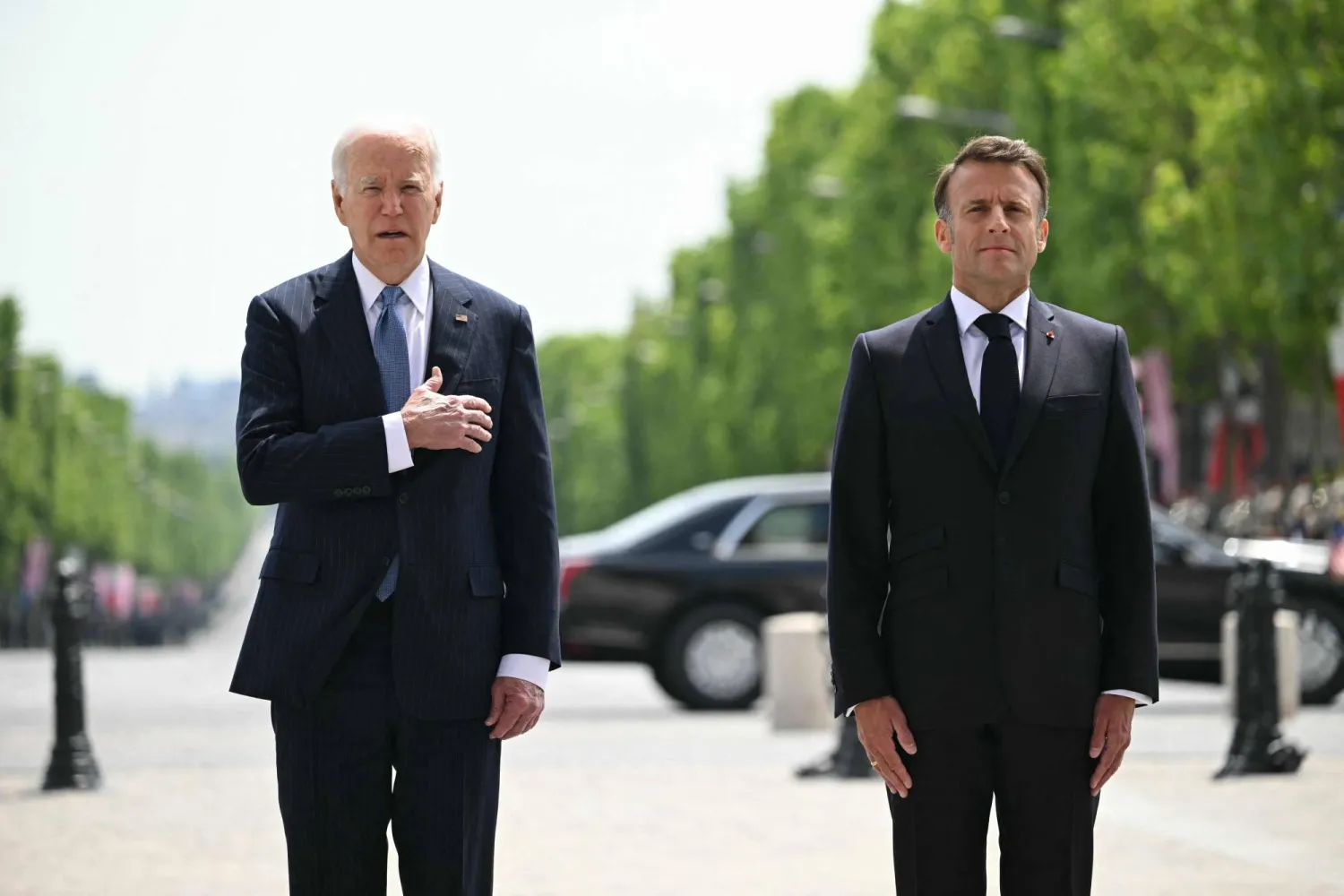 الرئيس الفرنسي إيمانويل ماكرون يستقبل نظيره الأميركي جو بايدن في قوس النصر بباريس (أ.ف.ب)