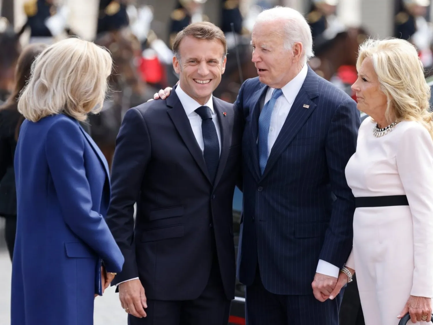 إيمانويل وبريجيت ماكرون لدى استقبالهما جو وجيل بايدن قرب قوس النصر السبت (أ.ب)