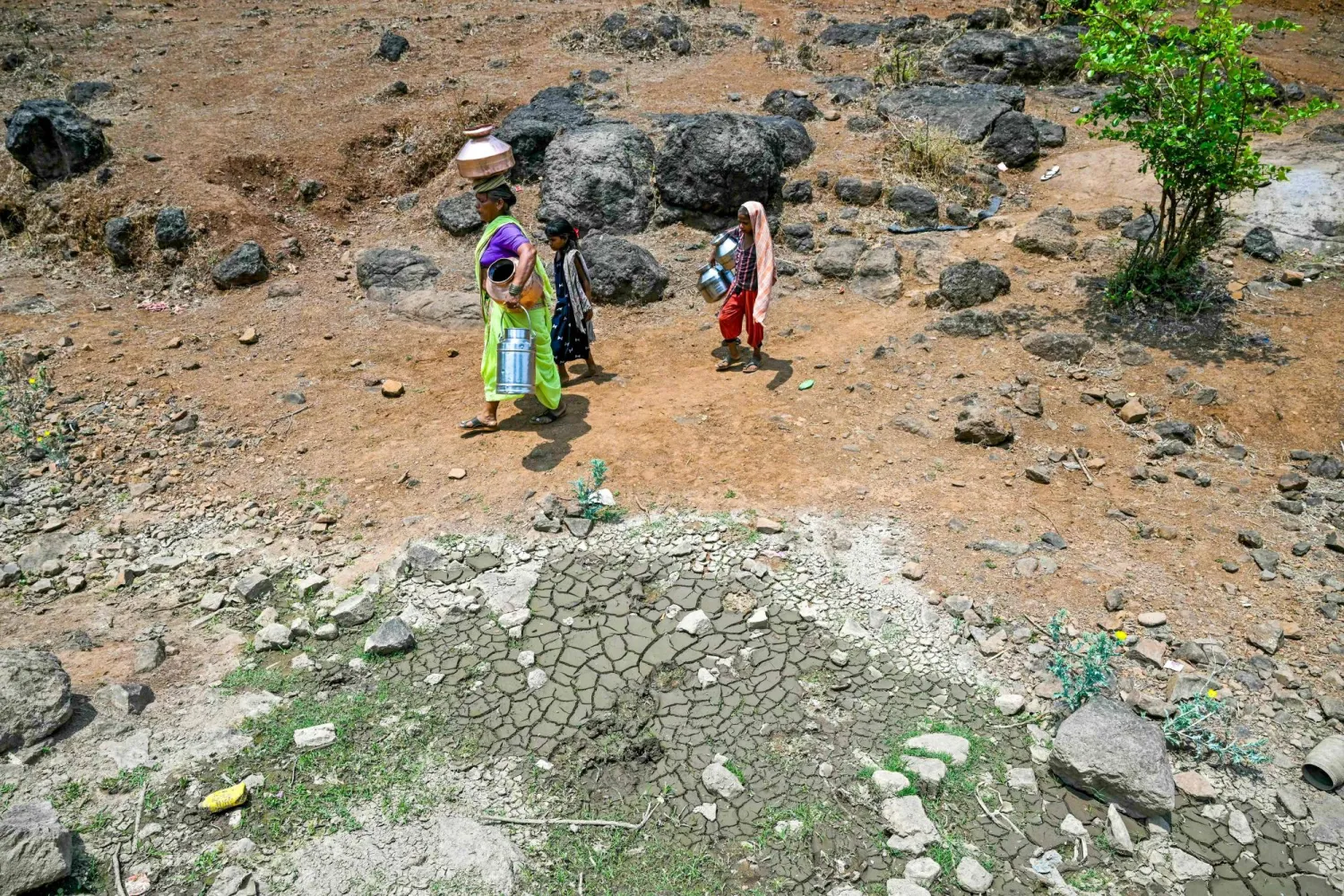 (FILES) In this photo taken on May 24, 2024, villagers carry water pots in Shahapur district of India's Maharashtra state, amid ongoing heatwave. (Photo by Indranil MUKHERJEE / AFP)