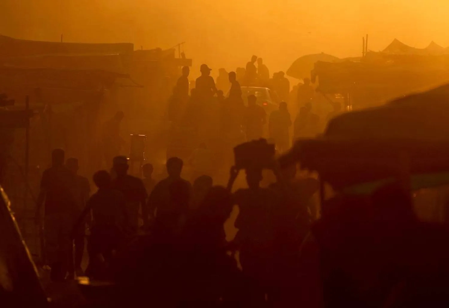  Palestinians walk and travel along a street, in an area where houses have been destroyed in Israeli strikes, amid the Israel-Hamas conflict, in Khan Younis, in the southern Gaza Strip, June 9, 2024. (Reuters)