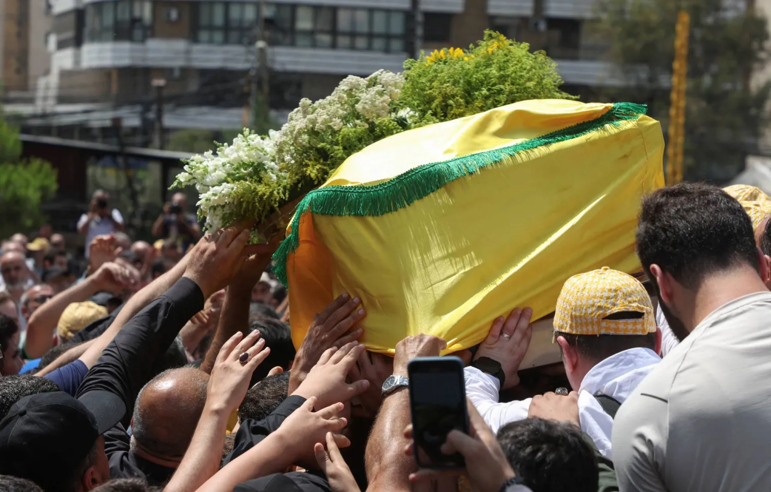 مشيعون يحملون نعش طالب عبد الله المعروف أيضاً باسم أبو طالب القائد الميداني الكبير في «حزب الله» الذي قُتل في غارة إسرائيلية ليلة أمس خلال جنازته في الضاحية الجنوبية لبيروت (رويترز) 