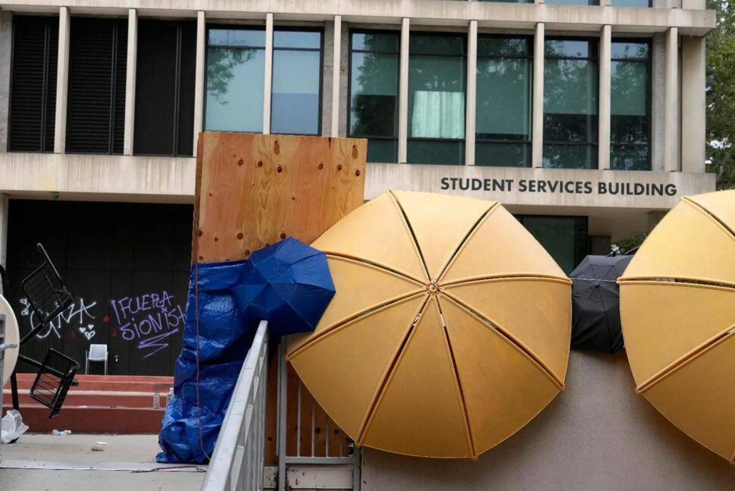 A barricade and graffiti are seen left by pro-Palestinian protesters at the Student Services Building at California State University, Los Angeles campus in Los Angeles, Thursday, June 13, 2024. A takeover of a building at the university by demonstrators protesting Israel's war against Hamas in Gaza ended early Thursday, leaving the facility trashed and covered with graffiti. (AP Photo/Damian Dovarganes)

