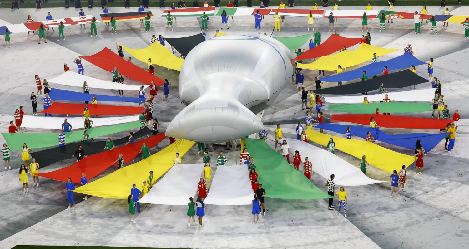 راقصون يتحلقون حول مجسم عملاق للكأس في حفل الافتتاح (رويترز)