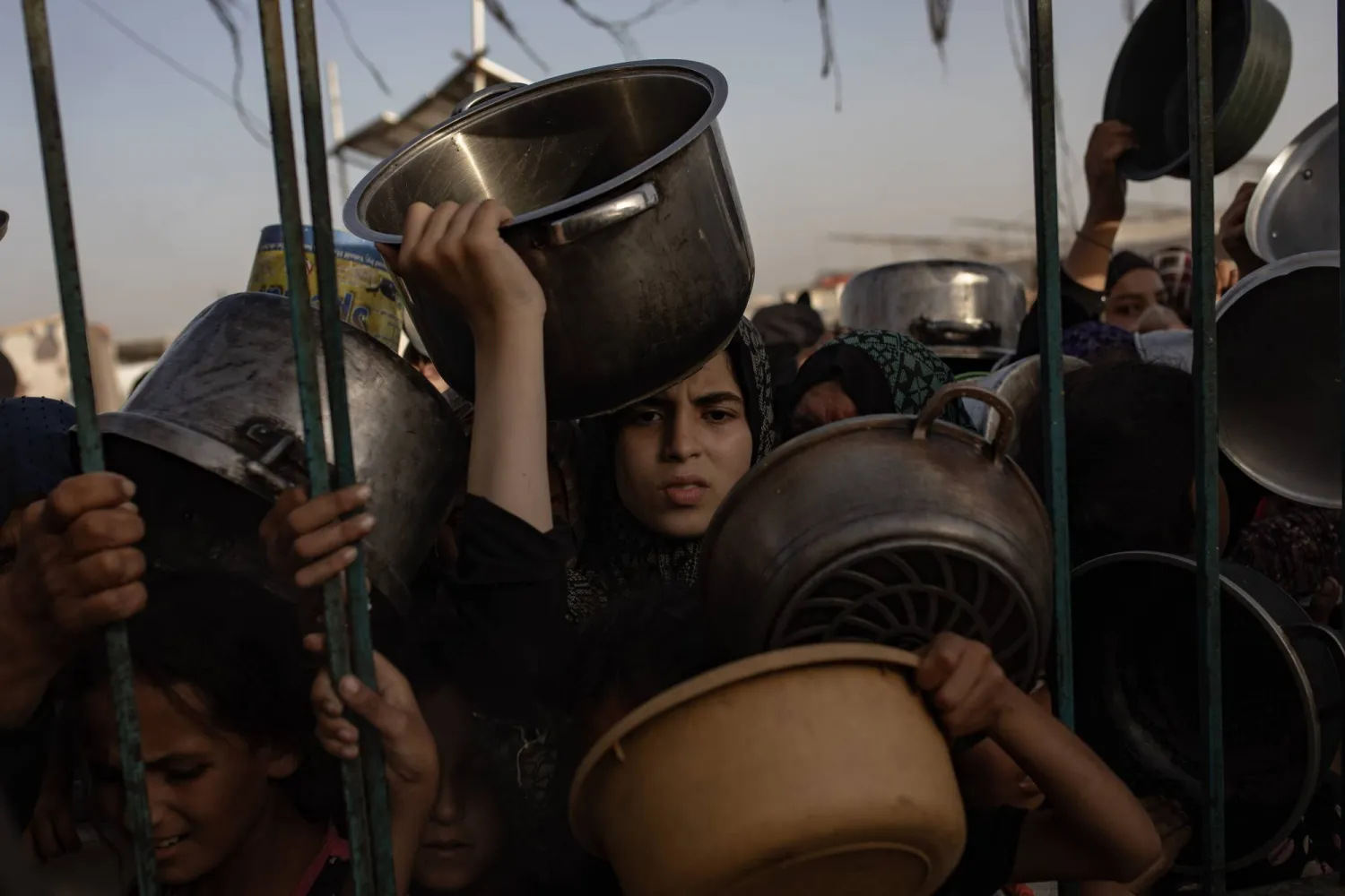Children stand at a gathering of internally displaced Palestinians to collect food donated by a charitable group, in Khan Yunis camp, southern Gaza Strip, 15 June 2024. EPA/HAITHAM IMAD