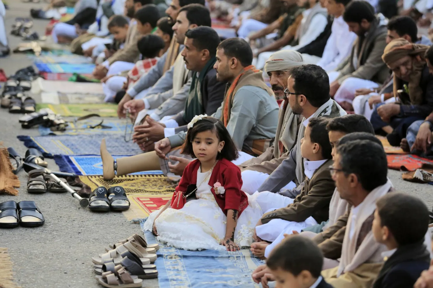 أطفال في ملابس العيد ينتظرون بداية الصلاة في صنعاء (إ.ب.أ)