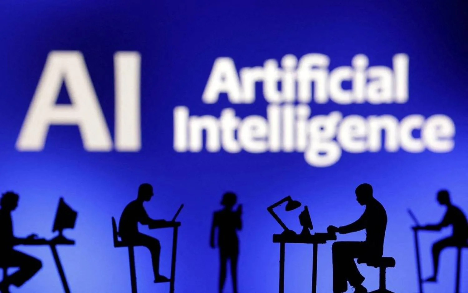 Figurines with computers and smartphones are seen in front of the words "Artificial Intelligence AI" in this illustration taken, February 19, 2024. (Reuters)