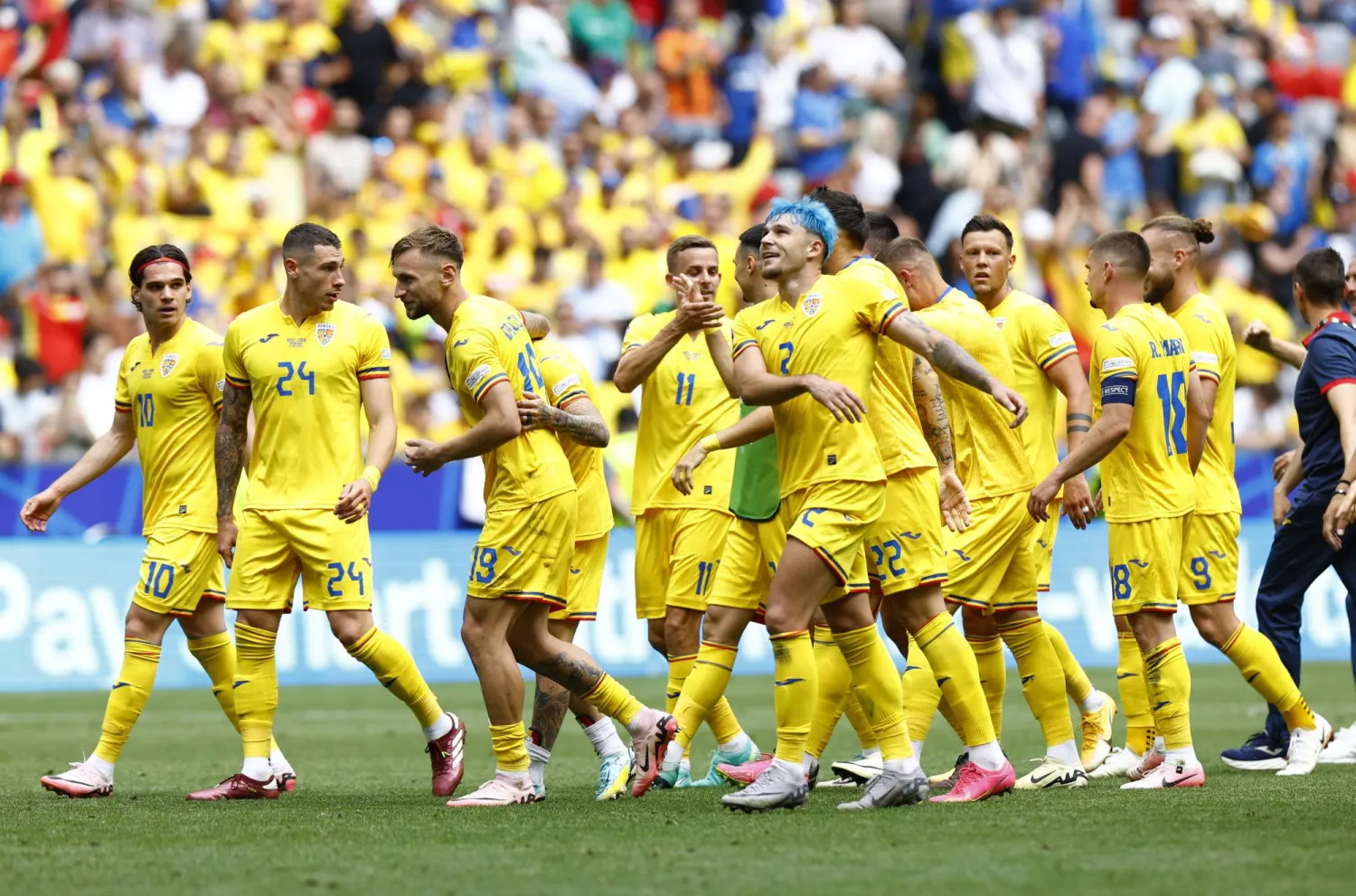 لاعبو رومانيا يحتفلون بالفوز على أوكرانيا في ميونيخ (رويترز)