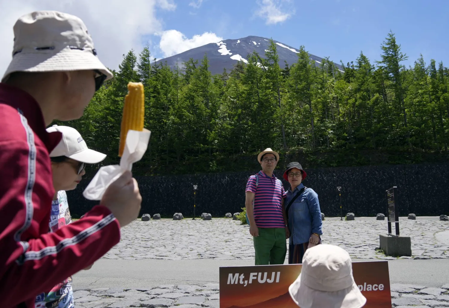 سائحون يلتقطون صوراً تذكارية عند سفح جبل فوجي الشهير في اليابان (أ.ب.أ)