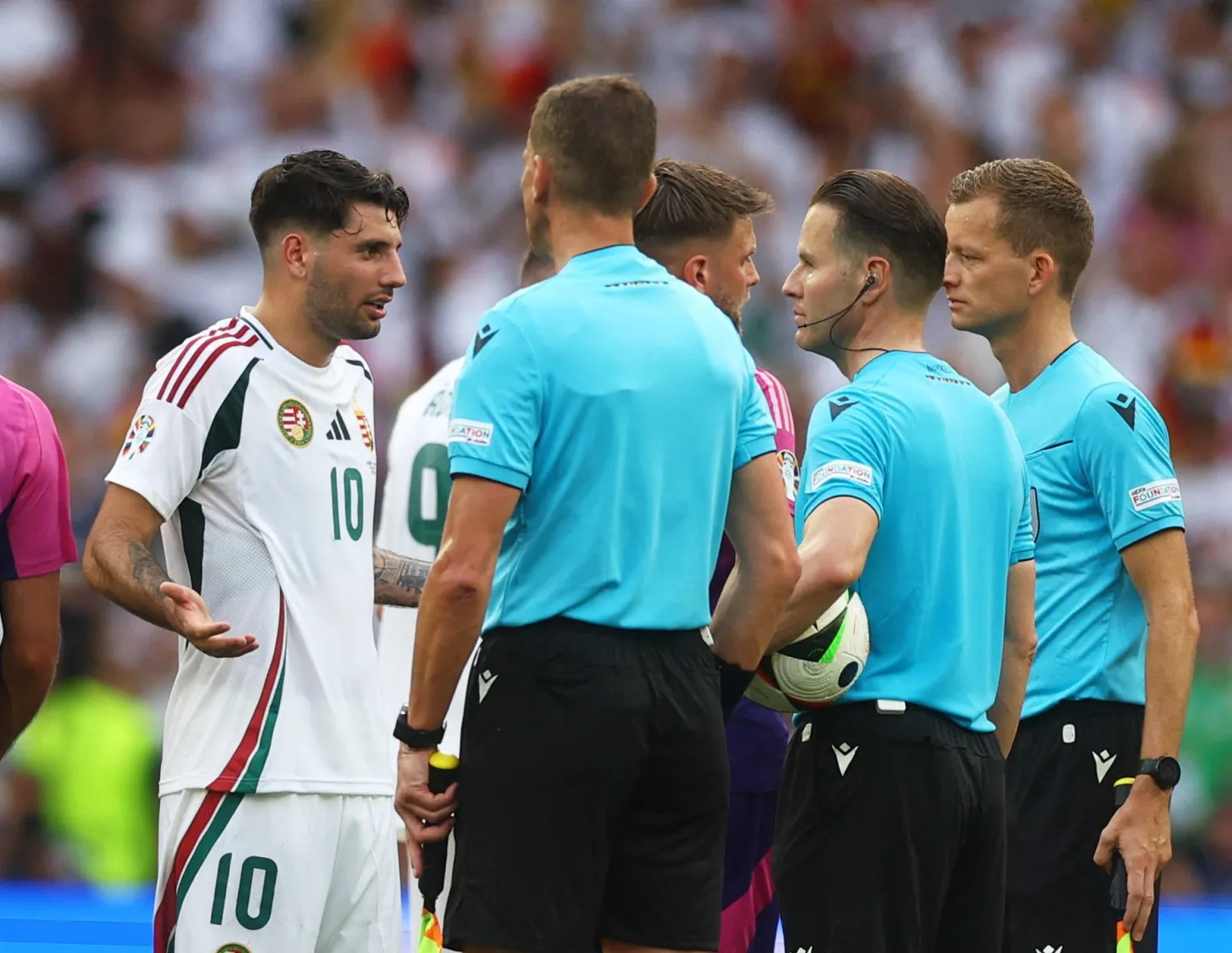 المجري دومينيك سزوبوسزلاي يناقش الحكم داني ماكيلي بعد نهاية المباراة (رويترز)