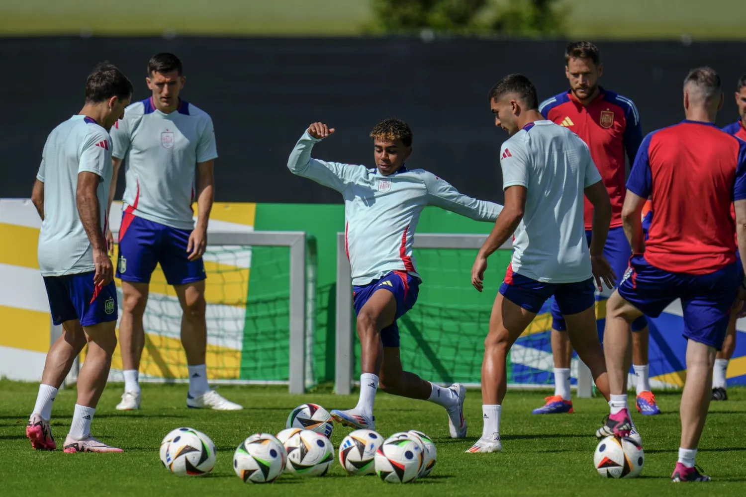 لاعبو منتخب اسبانيا يتوسطهم الواعد الموهوب لامين يامال خلال  التدريب قبل مواجهة إيطاليا (اب)