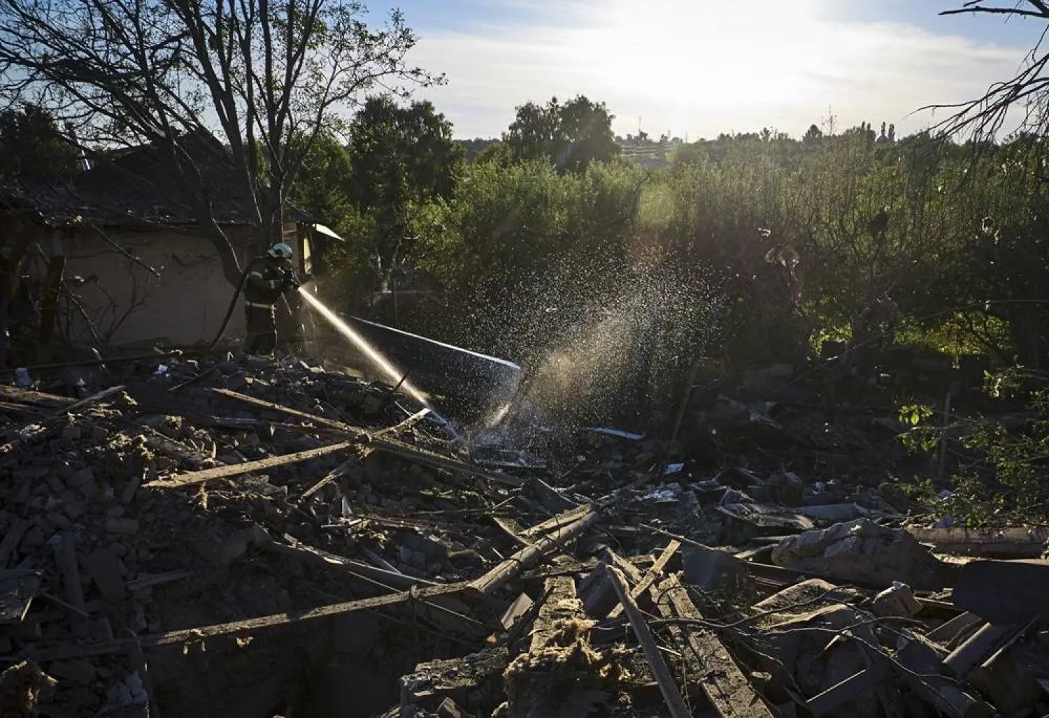 Ukrainian rescuers work at the site of a glide bomb attack on a private building in Vilkhivka village near Kharkiv, northeastern Ukraine, 19 June 2024, amid the Russian invasion. (EPA) 