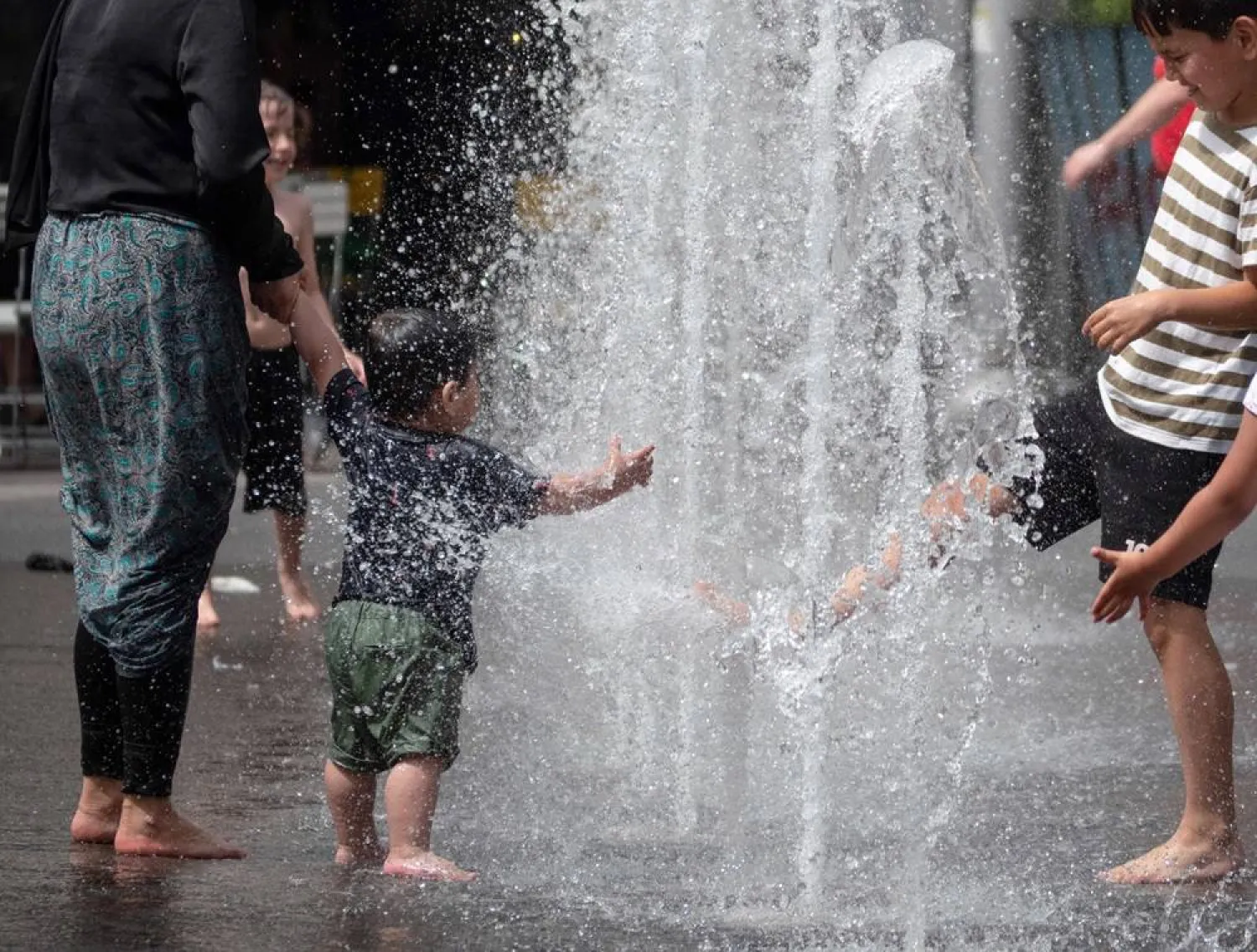  Children enjoy the cold water of a fountain at Columbus Square in Vienna as Austria is being hit by extreme heat on June 21, 2024. (AFP)
