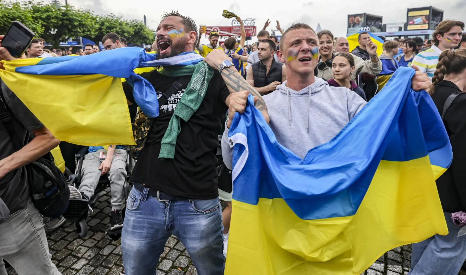 مشجعون أوكرانيون يحتفلون بفوز منتخبهم في إحدى ساحات دوسلدورف القديمة (د.ب.أ)
