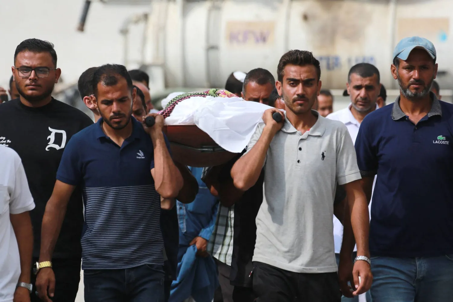 رجال فلسطينيون يحملون جثة لدفنها قُتلت في اليوم السابق في غارة على منطقة المواصي شمال غربي مدينة رفح الفلسطينية في 22 يونيو (أ.ف.ب)