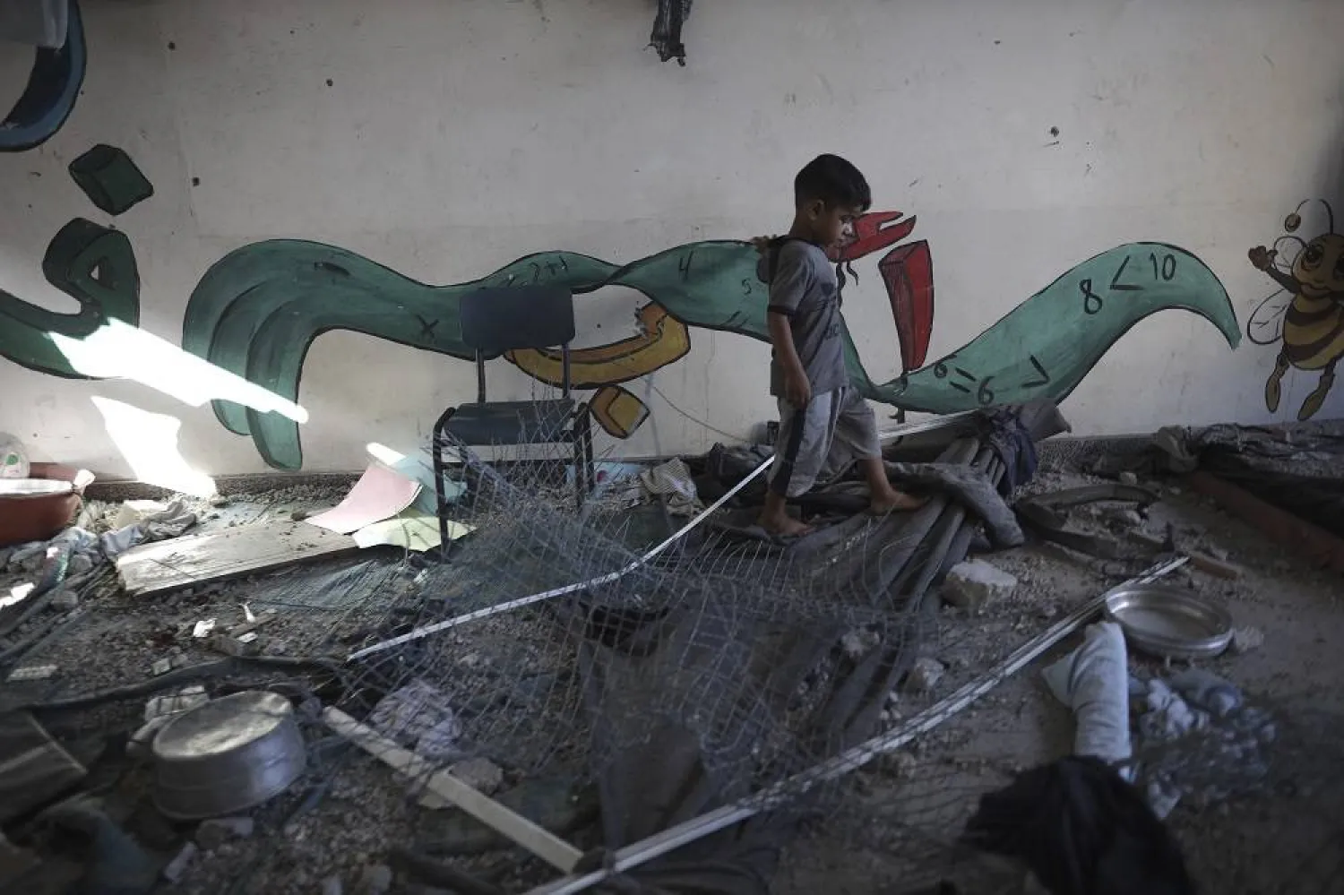 A Palestinian child navigates through heavy damage to a UNRWA school sheltering displaced persons the day after a nearby house was targeted by Israeli bombardment in Khan Younis, southern Gaza Strip, Friday, June 21, 2024. (AP) 
