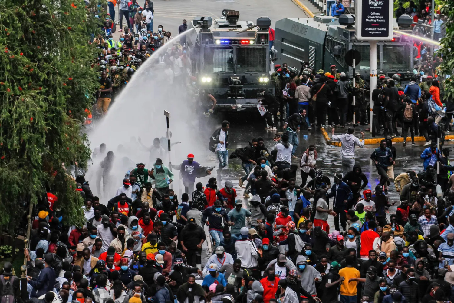 ضباط الشرطة يطلقون خراطيم المياه على المتظاهرين ضد مشروع القانون المالي في المنطقة التجارية المركزية (رويترز)