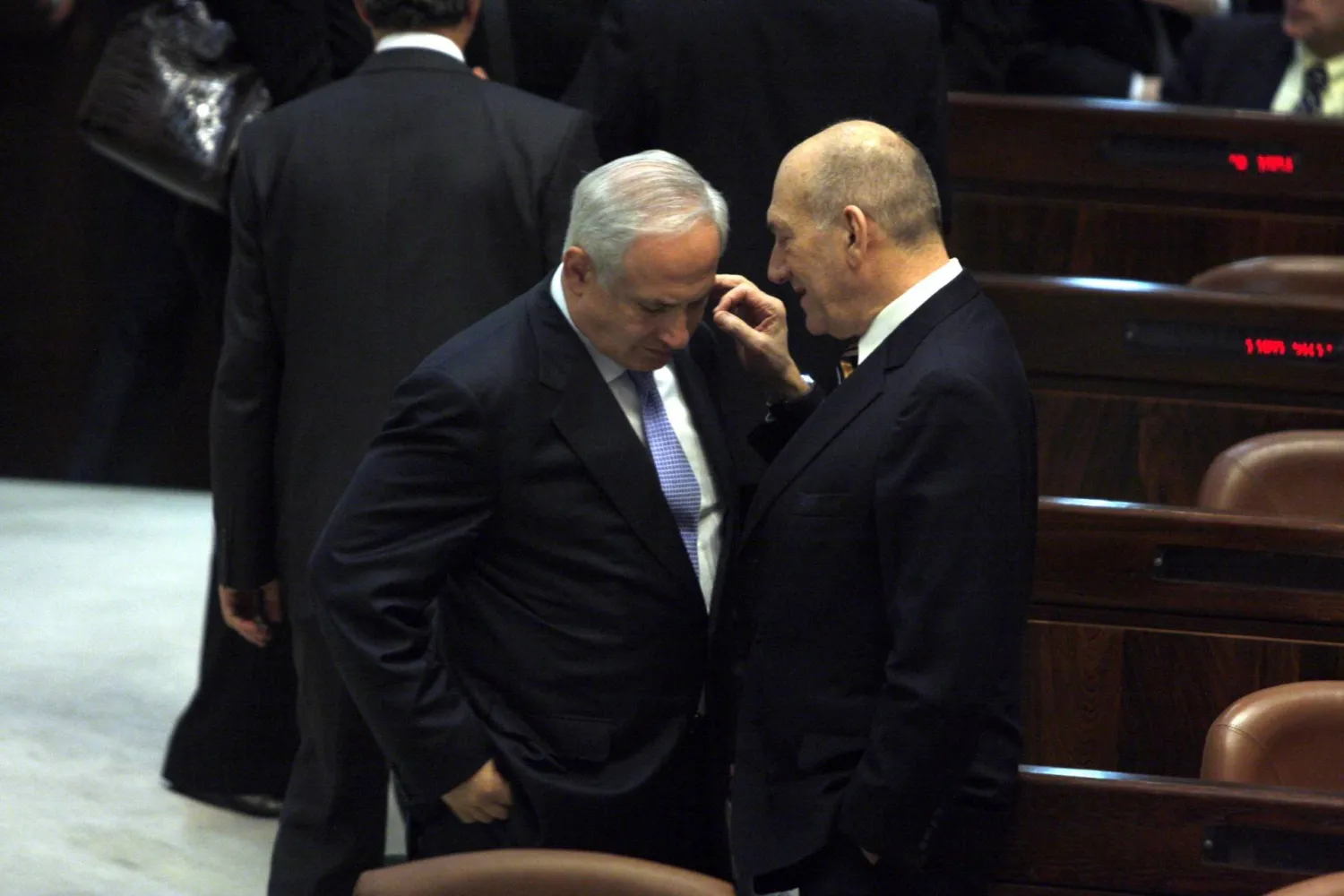أرشيفية لرئيس الوزراء الإسرائيلي المنتهية ولايته إيهود أولمرت (يمين) مع رئيس الوزراء الجديد بنيامين نتنياهو خلال اليمين الدستورية للحكومة الجديدة في الكنيست 31 مارس 2009 (غيتي)