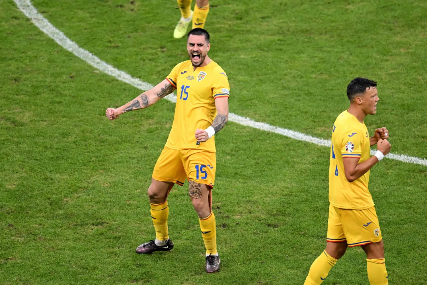 أندريه بيوركا لاعب منتخب رومانيا والأخدود السعودي محتفلاً بالتأهل إلى دور الـ16 (أ.ف.ب)