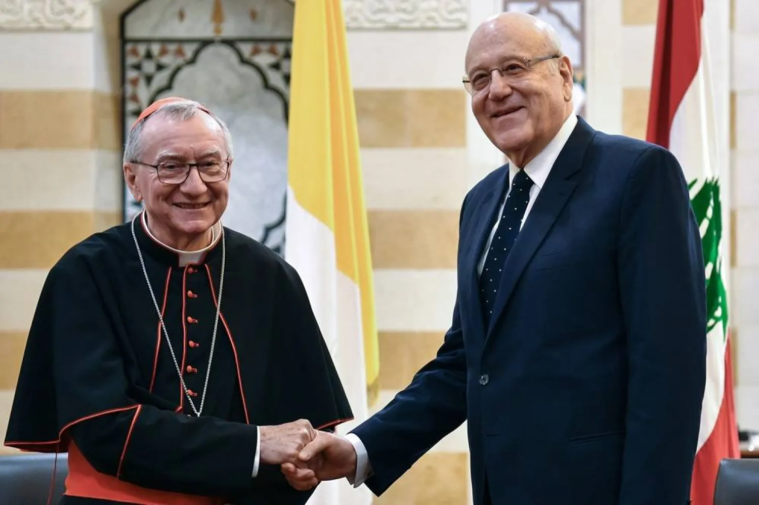 Lebanese caretaker Prime Minister Najib Mikati (R) shakes hands with the Holy See Secretary of State Cardinal Pietro Parolin (L) during their meeting at the government palace in downtown Beirut, Lebanon, 26 June 2024. Cardinal Parolin is on a five-day state visit to Lebanon. (EPA) 