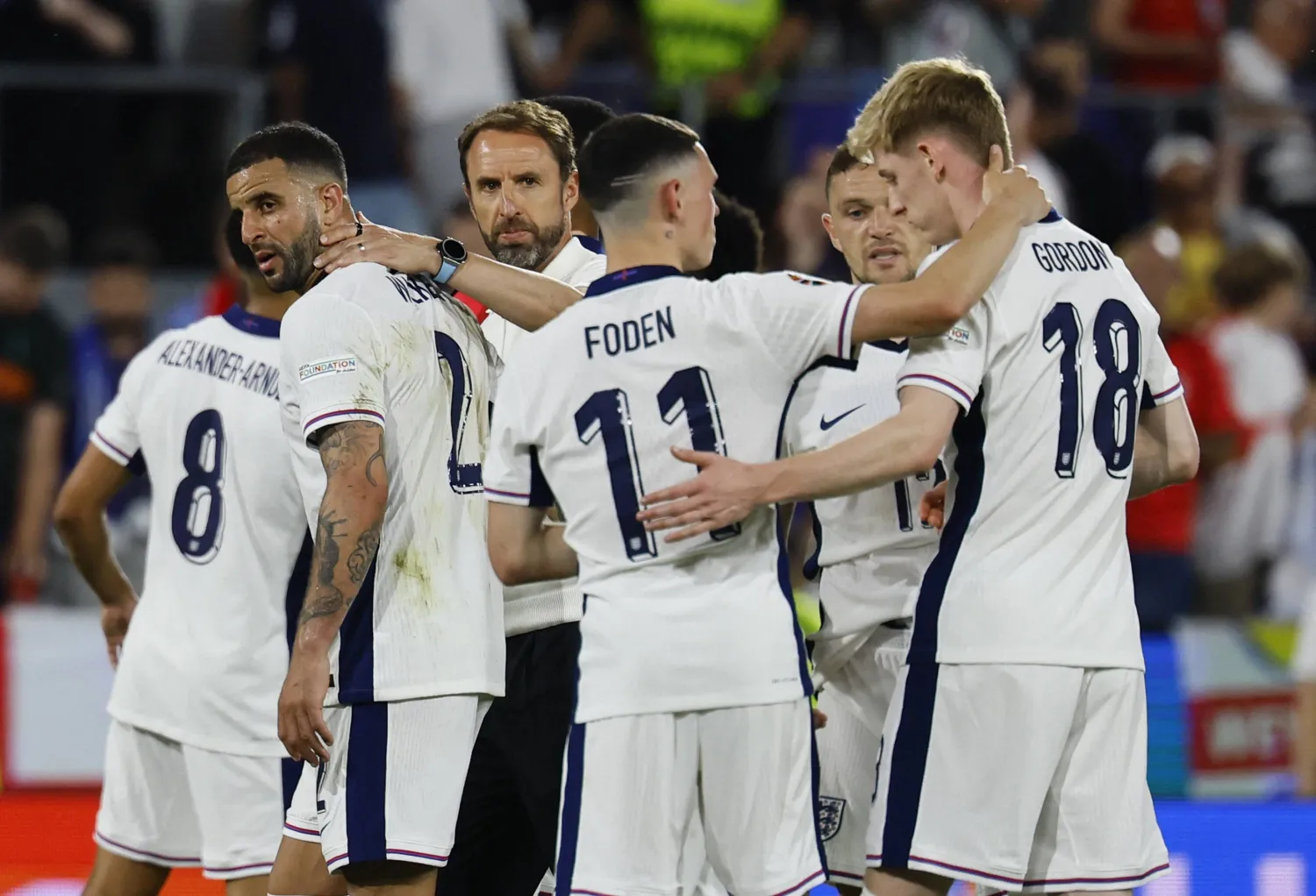 ساوثغيت ينظر للاعبي إنجلترا وسط احتفالهم بالتأهل الباهت (رويترز)