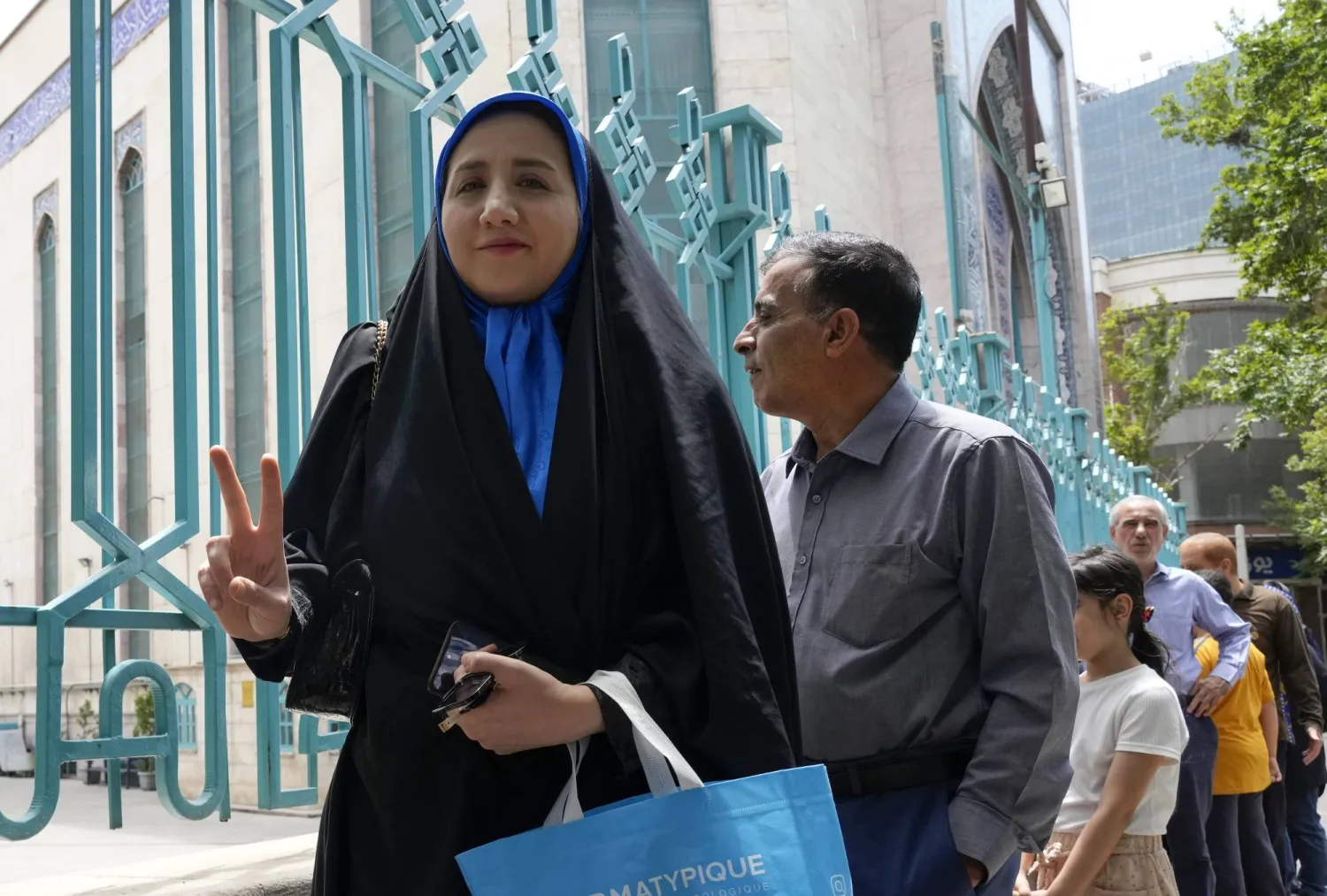 إيرانية تقف في طابور أمام مركز الاقتراع في «حسينية إرشاد» في «شارع شريعتي» وسط طهران (أ.ب)