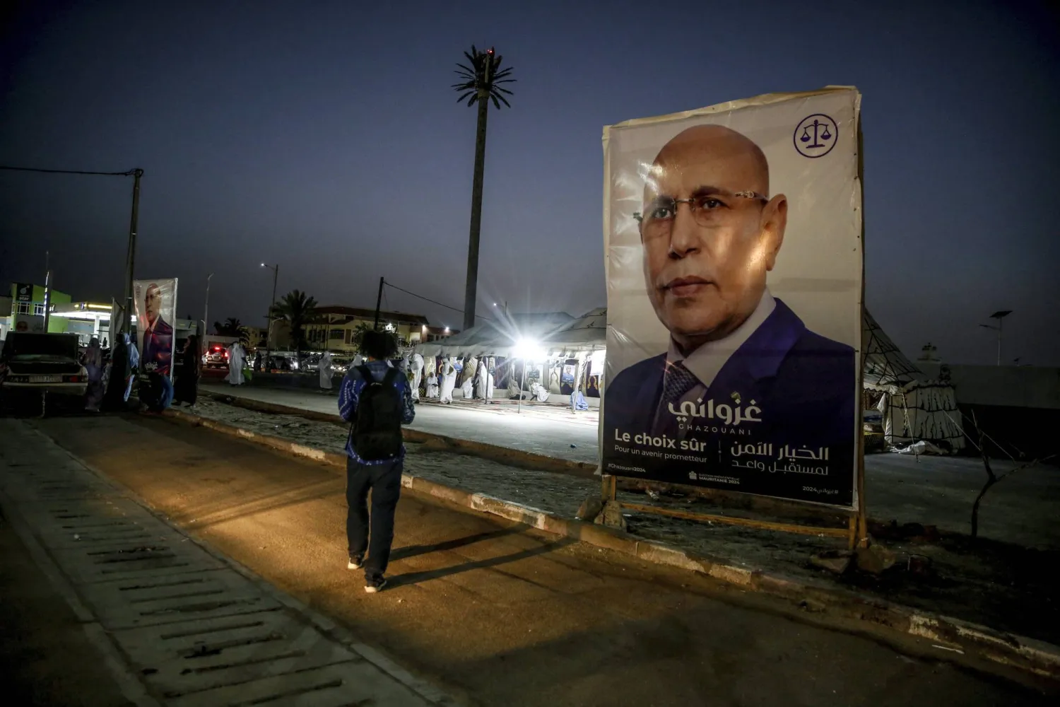 An electoral banner for Mauritanian president Mohamed Ould Ghazouani is placed during a campaign rally, ahead of the presidential elections in Nouakchott, Mauritania, Wednesday, June 26, 2024. Banner in Arabic reads: "Safe choice." (AP Photo/Mamsy Elkeihel)