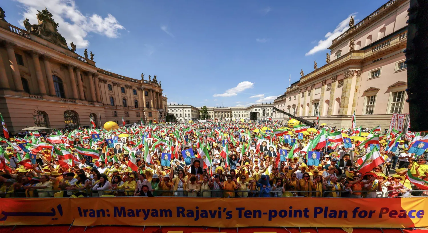 يرفع متظاهرون الأعلام الإيرانية في مسيرة نظمتها منظمة «مجاهدين خلق» في برلين اليوم (إ.ب.أ)